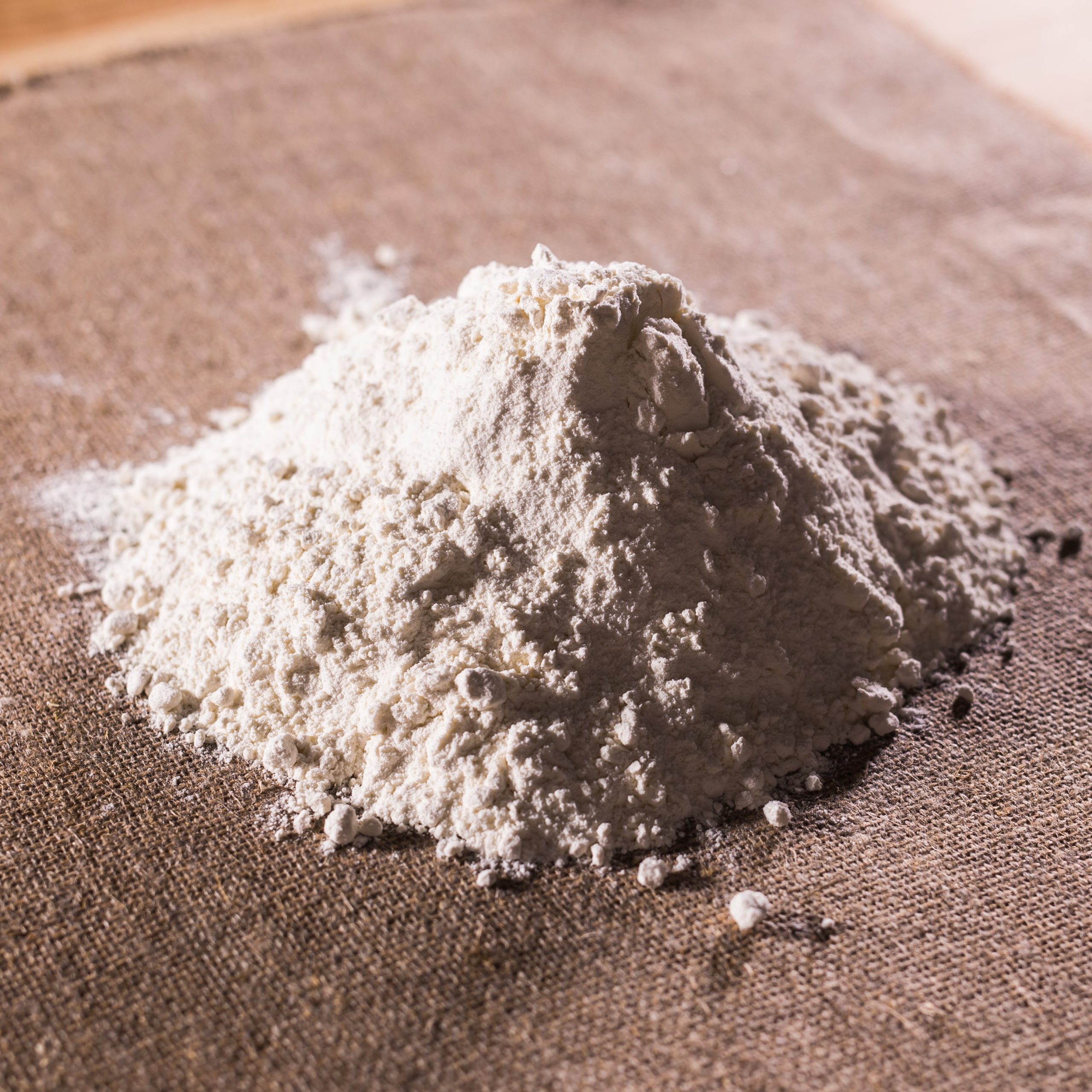 Heap of dry flour on textile. Cooking flour products concept